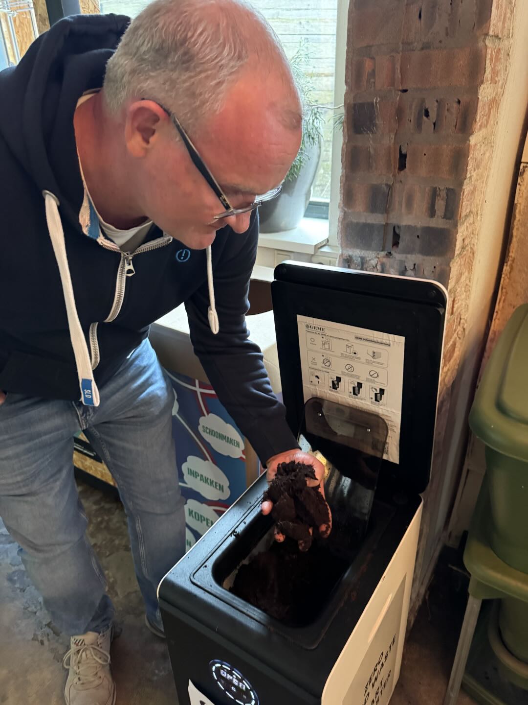 Fresh GEME compost straight from the composter, showing rich dark color and ideal moisture content